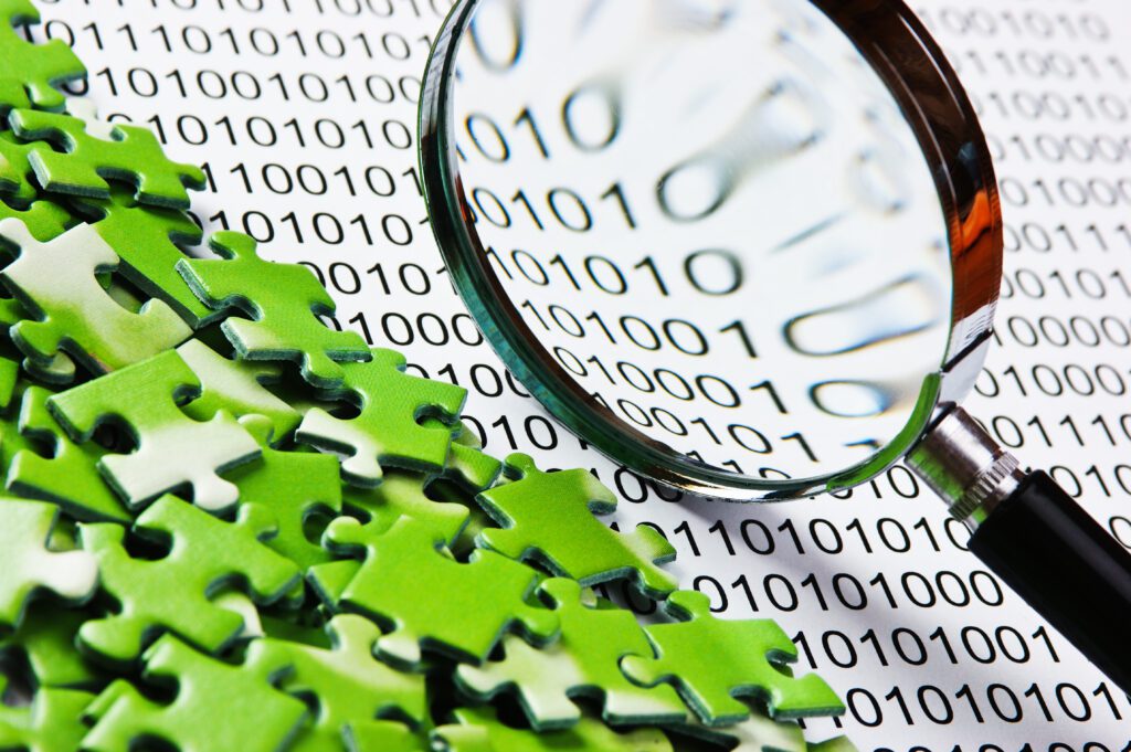 Green puzzle pieces on a binary background with a magnifying glass to demonstrate choosing a software integration tool